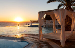 Luxury sunbed and infinity pool at sunset