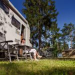 Woman resting near motorhomes in nature. Family vacation travel,